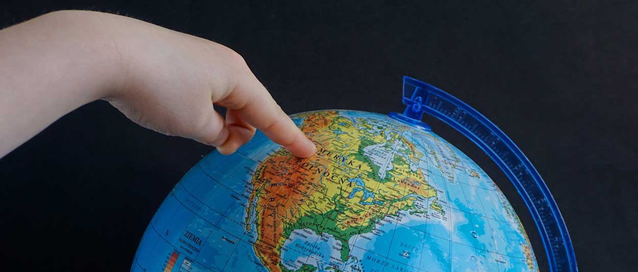 Finger on globe of North America