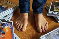 man's feet with magazines